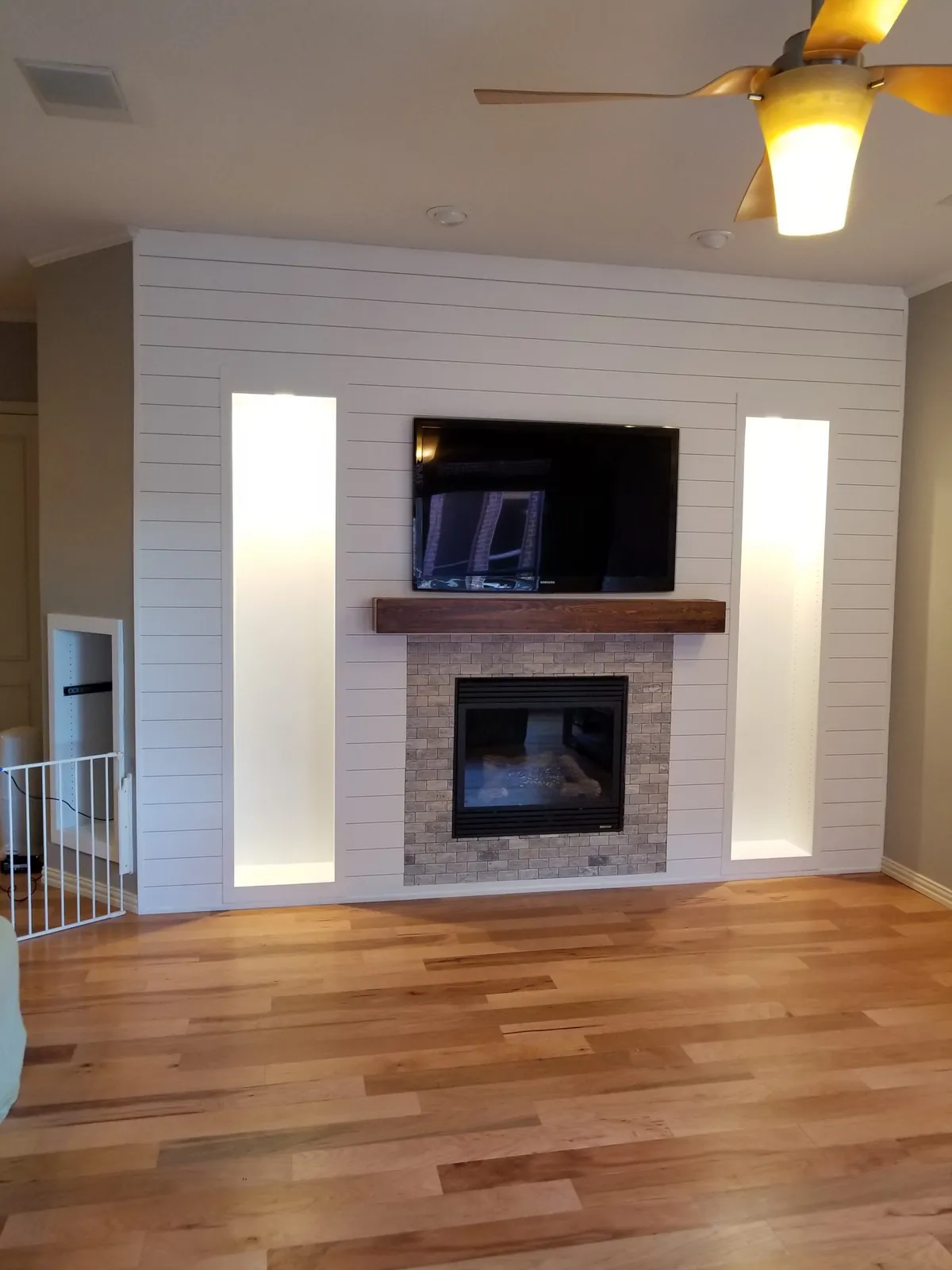 Shiplap fireplace wall with lit shelving niches