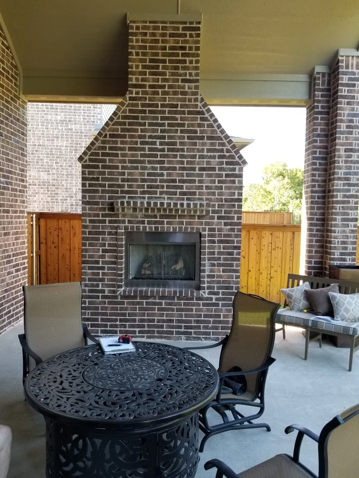 Brick outdoor fireplace on a covered patio