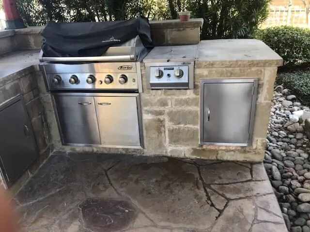 Stone outdoor kitchen with a built-in grill