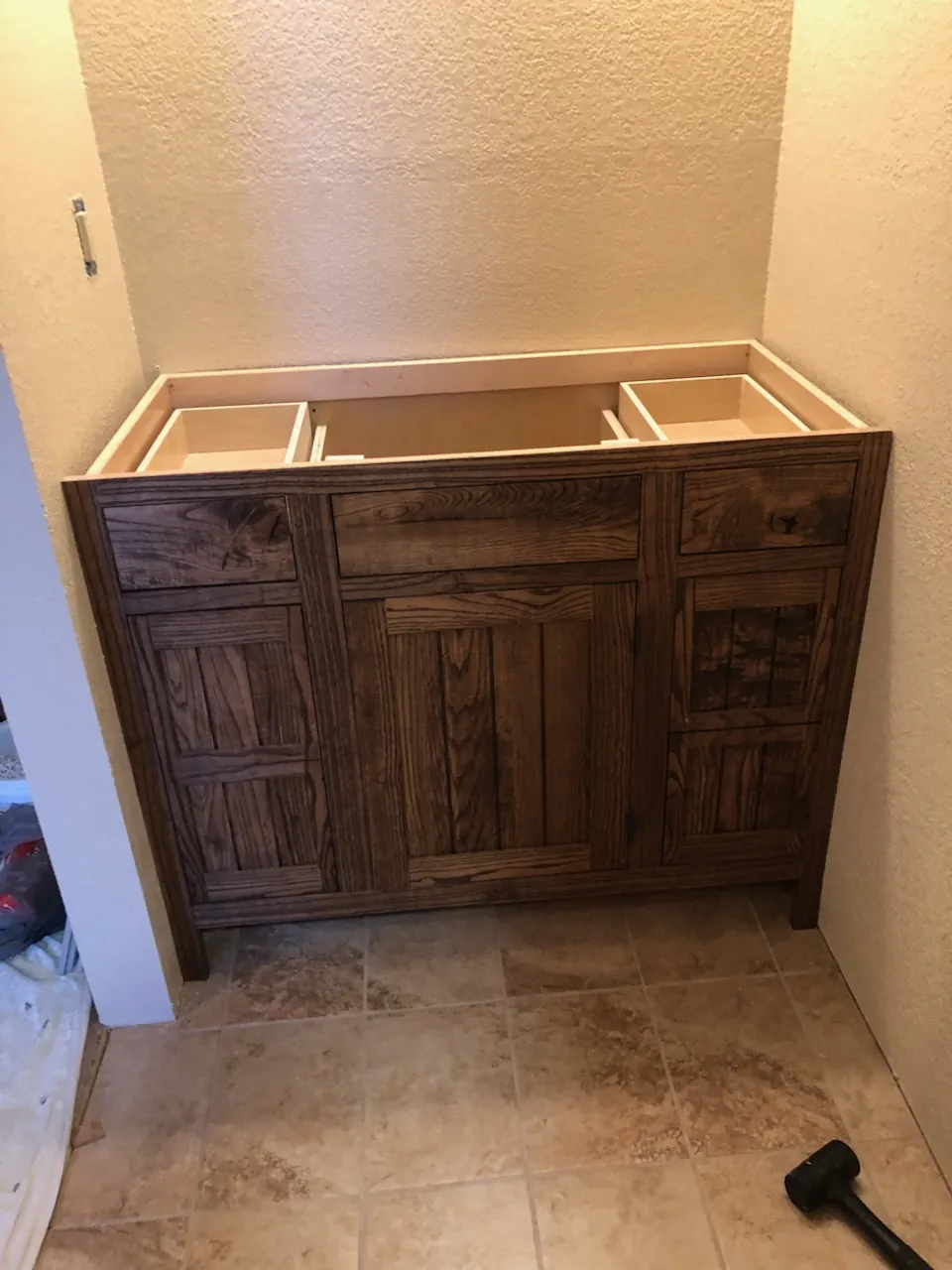 Stained vanity cabinet being installed