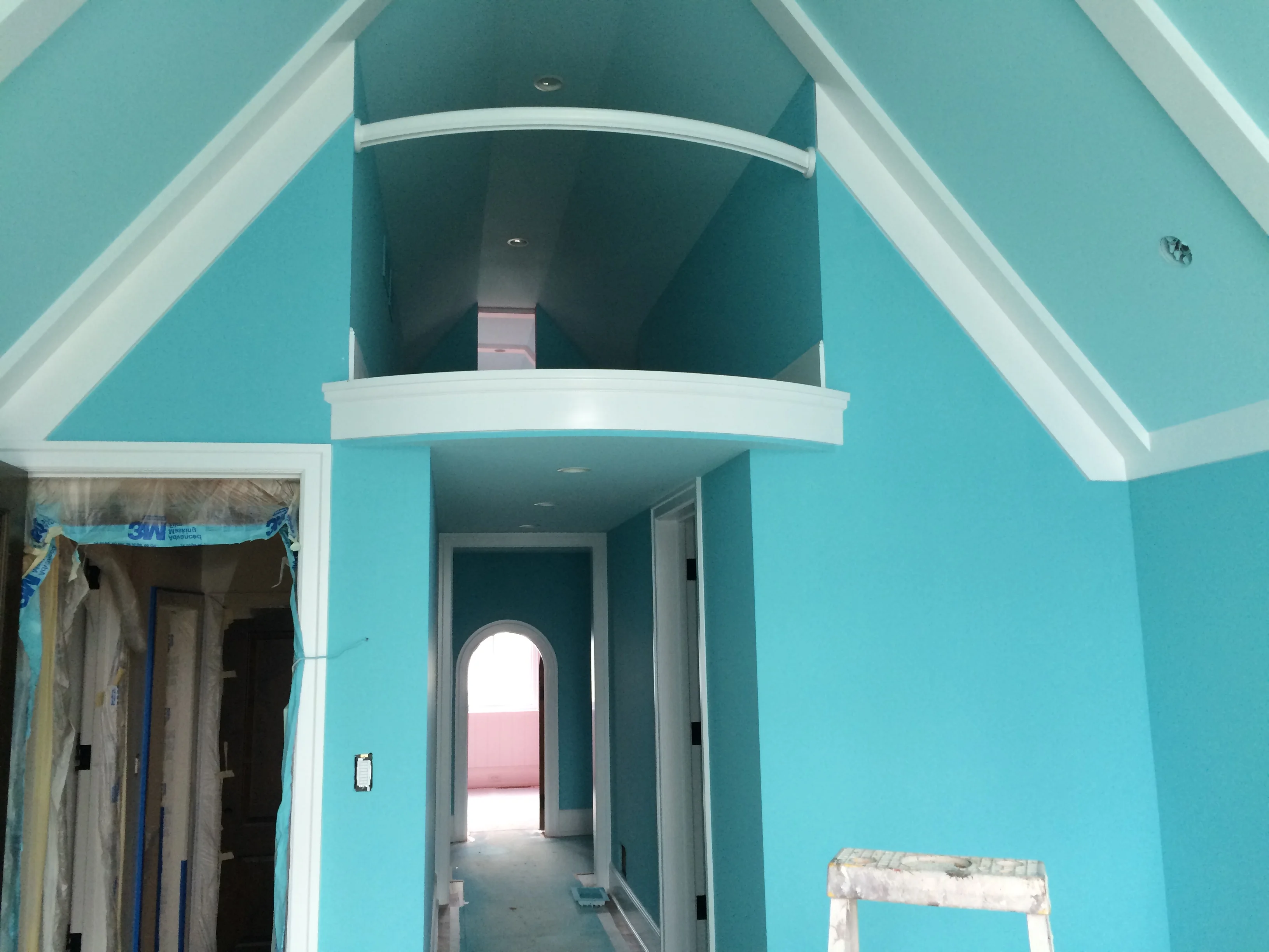 Interior drywall and ceiling construction in a residential space with turquoise-painted walls and white trim details.