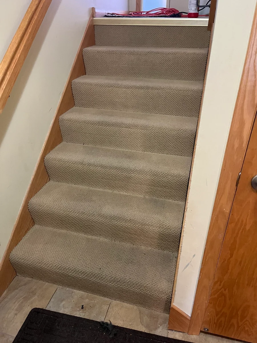 Carpet cleaning on residential stairs in a home interior.
