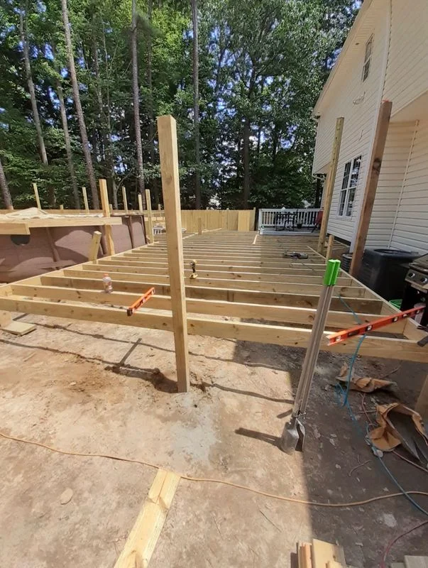 Deck framing and construction in progress on a residential home addition project.