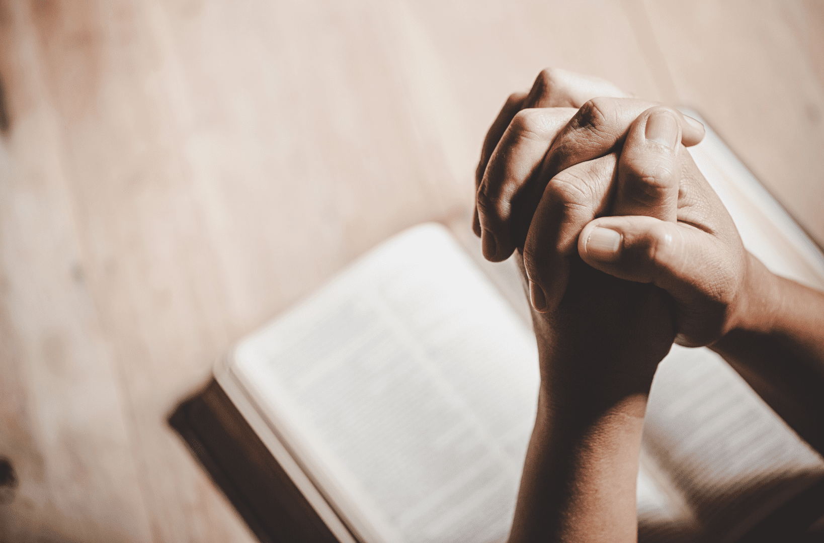 Prayer - hands clasped in prayer over a Bible