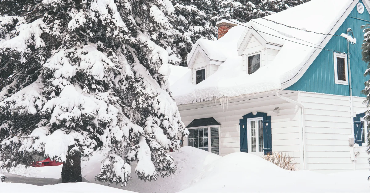 Snow covered white and blue residential home with gabled dormers during a Minneapolis winter