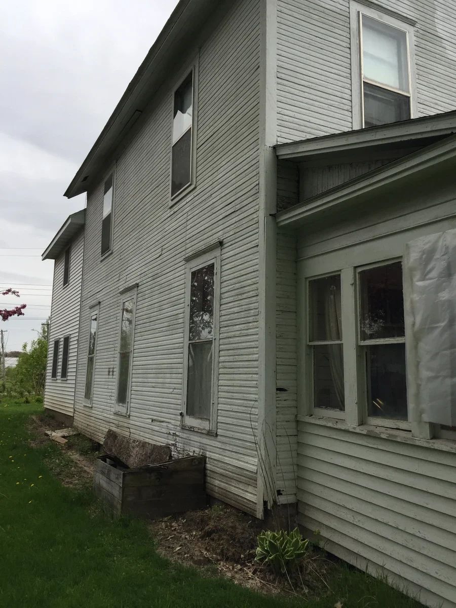 Vinyl siding and window installation on the exterior of a residential home showing multiple replacement windows.